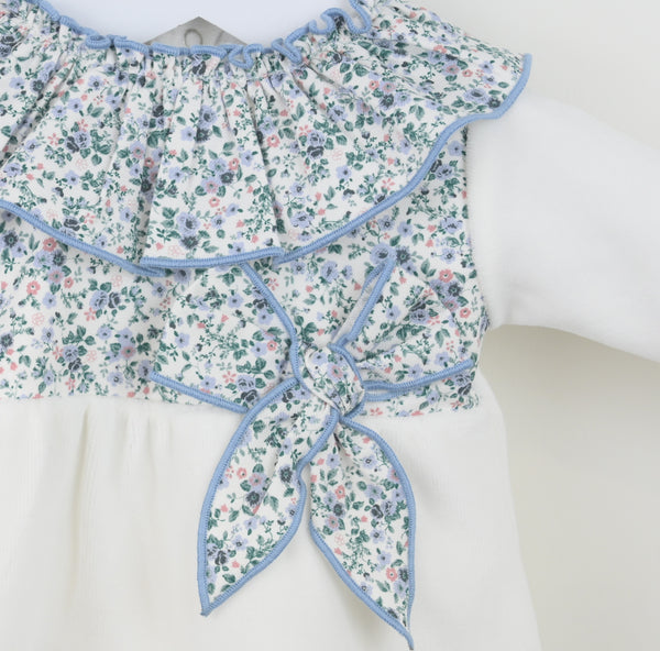 Floral bow with blue trim on a velour outfit against a white background