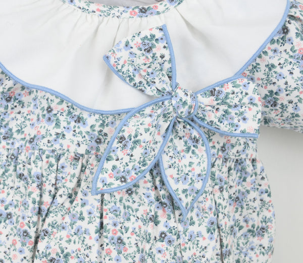 Floral romper with a large bow on a white background