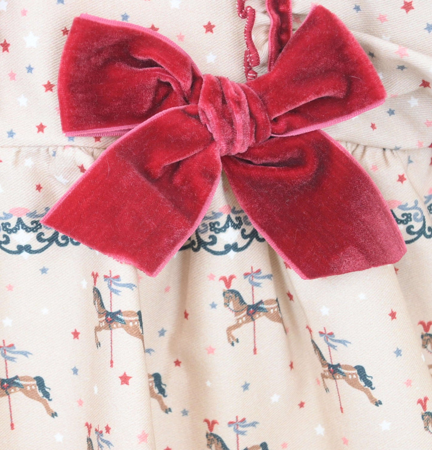 Red velvet bow on a fabric background with horse pattern
