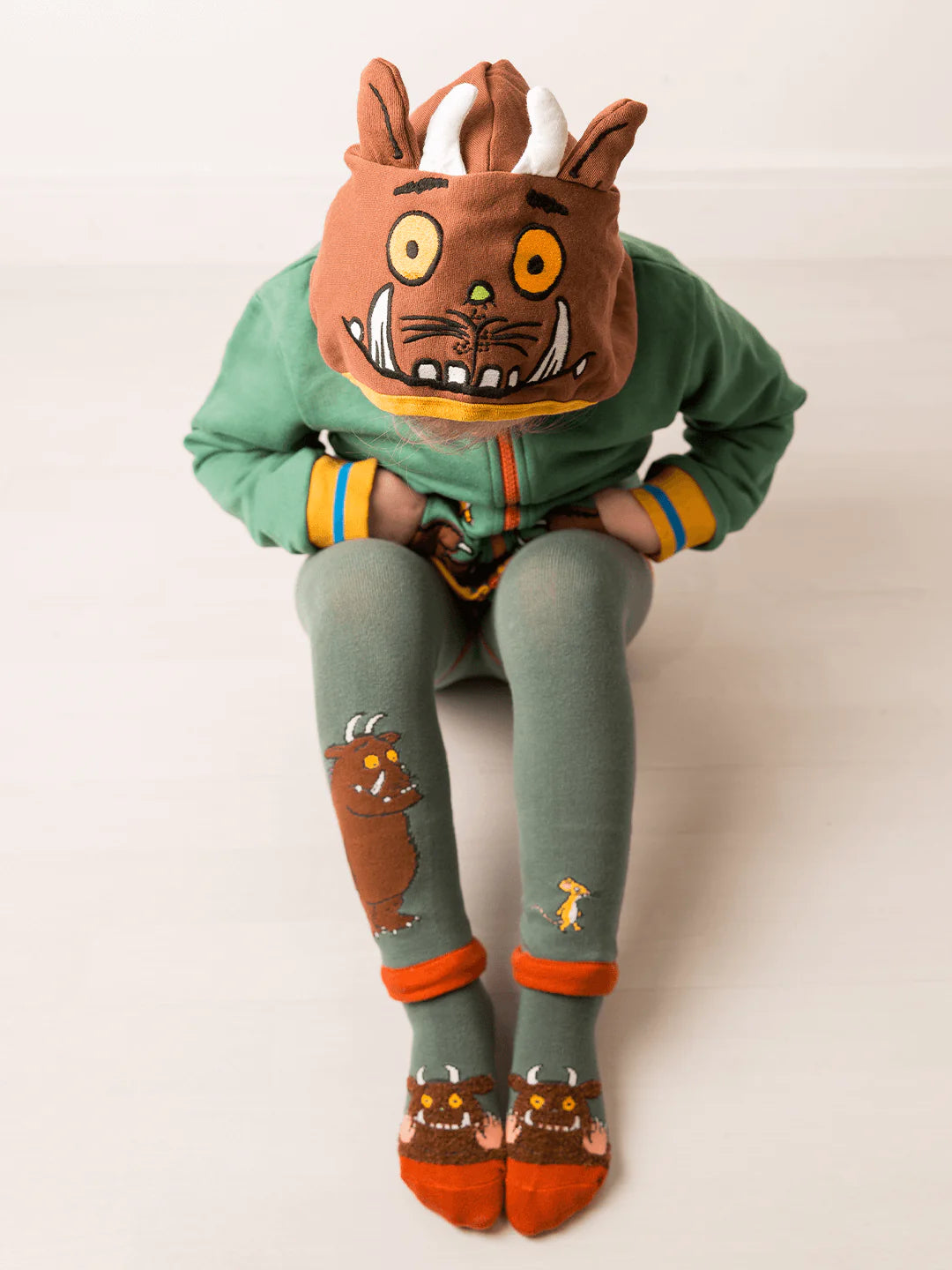 Child in Gruffalo hoodie and leggings on a white background