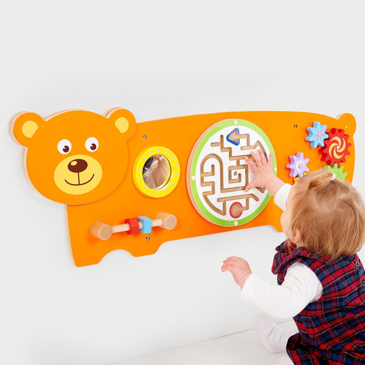Child interacting with a colorful educational toy shaped like a bear on a white background