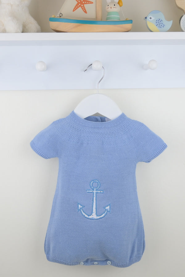 Blue baby romper with an anchor design on a white hanger against a light blue background.