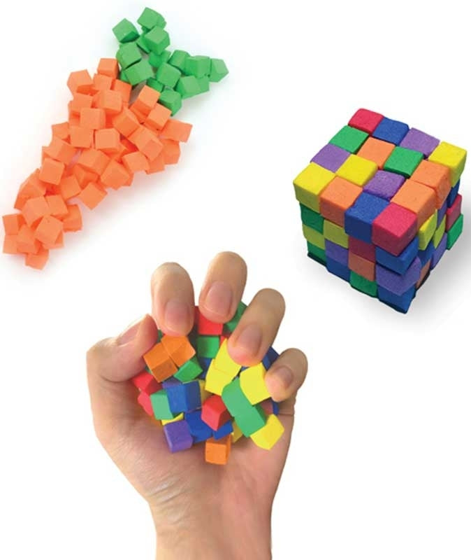 Colorful building blocks shaped like a carrot and a cube, with a hand holding a small stack of blocks.
