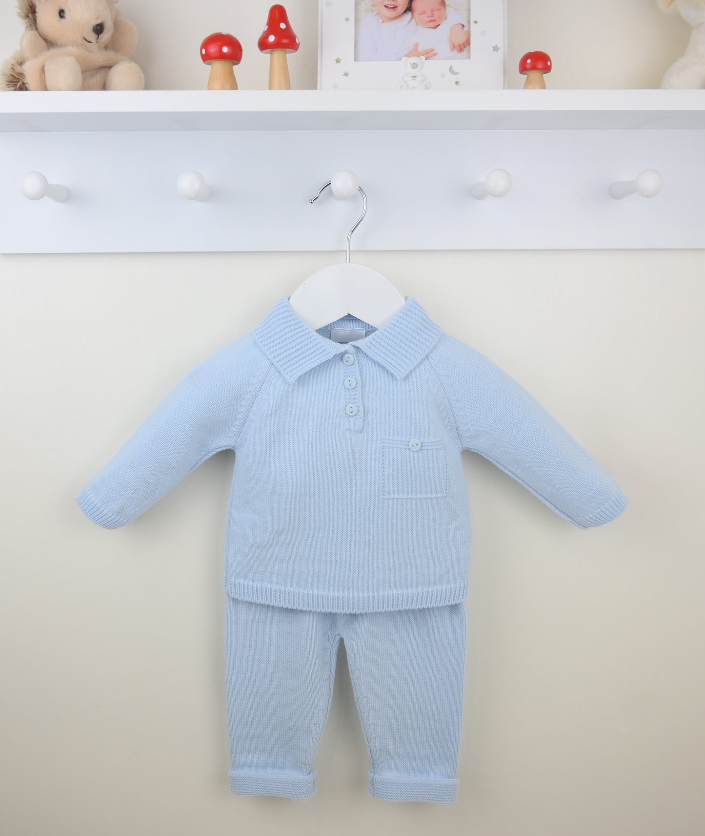 Light blue baby outfit on a hanger against a white background