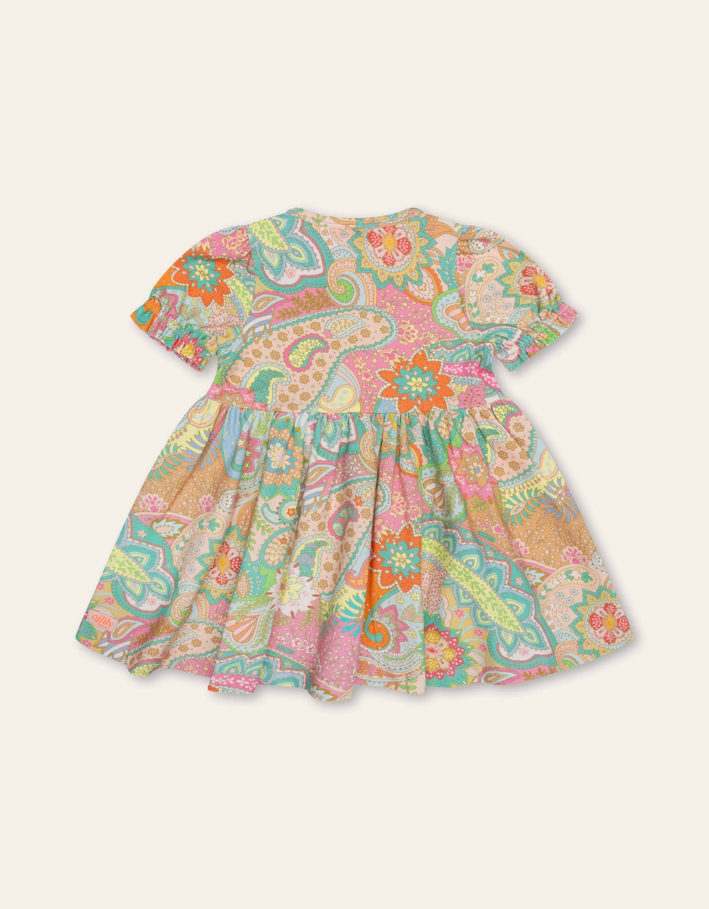 Colorful paisley patterned dress on a light beige background