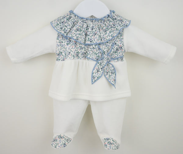 Baby outfit with floral top and white pants on a mannequin against a white background