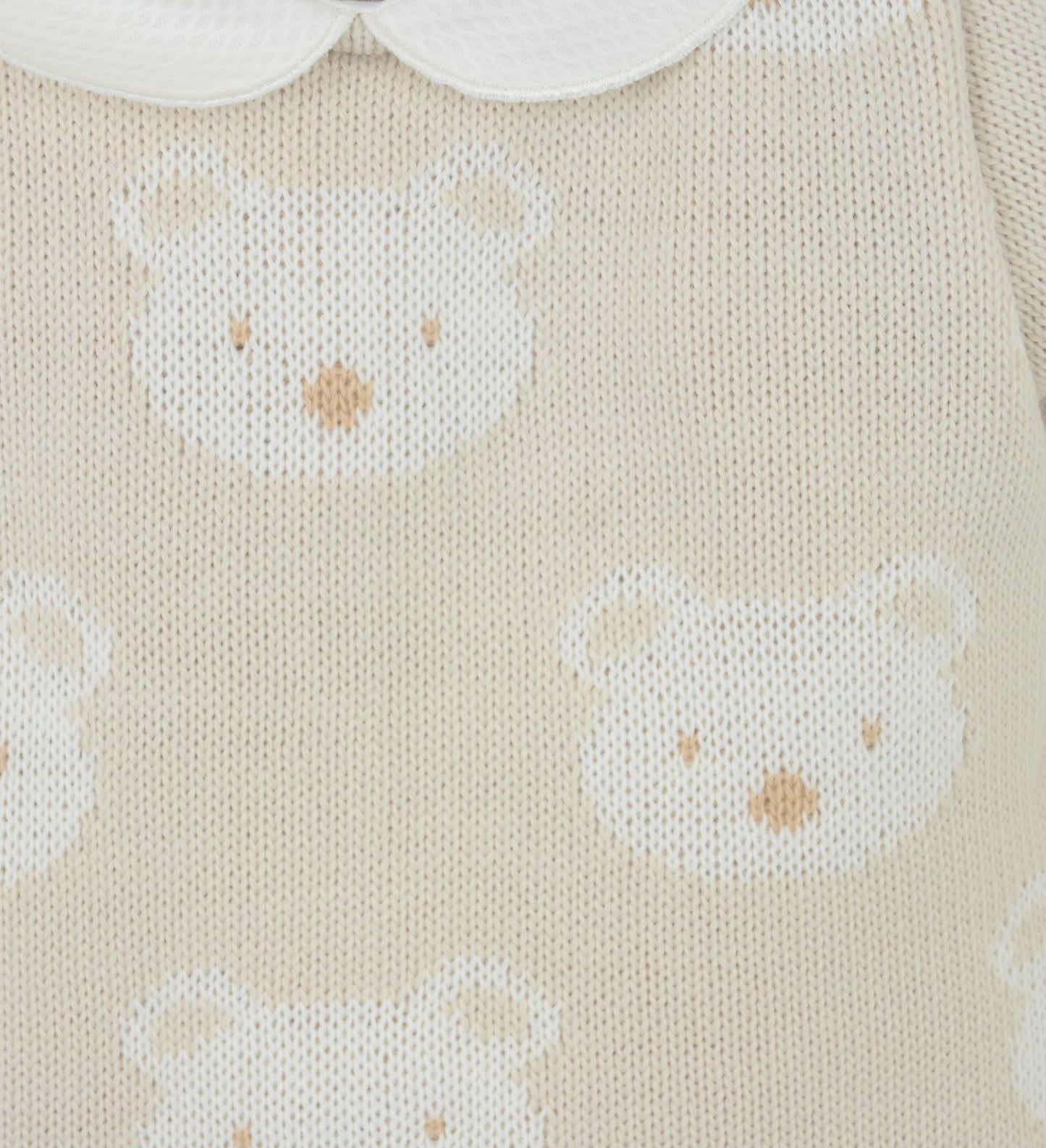 Close-up of knitted fabric with white bear patterns on a beige background