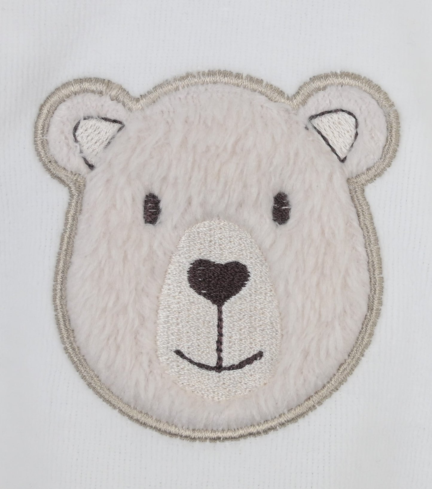 Embroidered patch of a bear's face on a white background