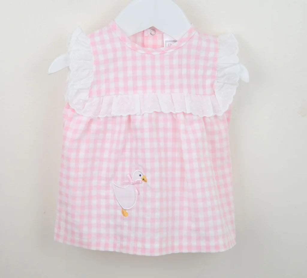 Pink checkered dress with white collar and goose design on a beige background