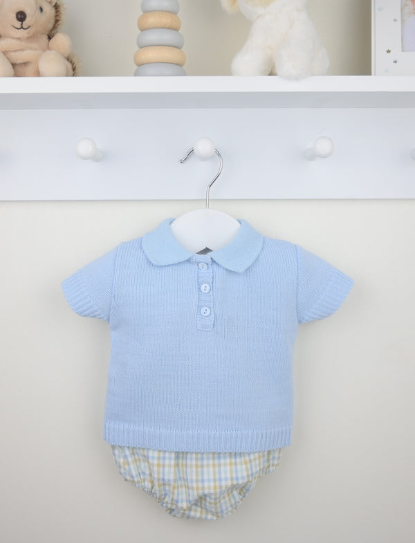 Baby outfit with light blue shirt and checkered shorts on a hanger against a white background.