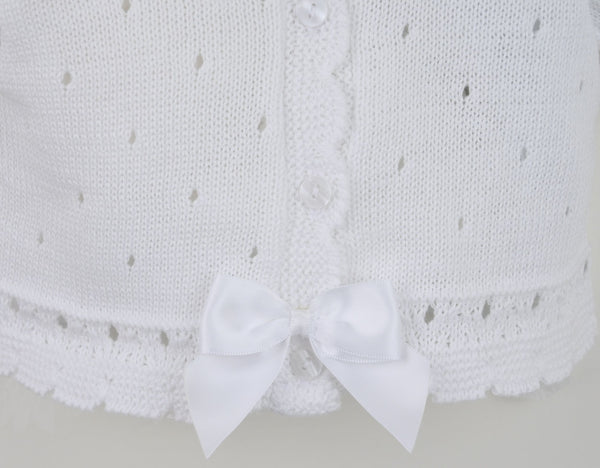 White knitted cardigan with bow details on a light gray background