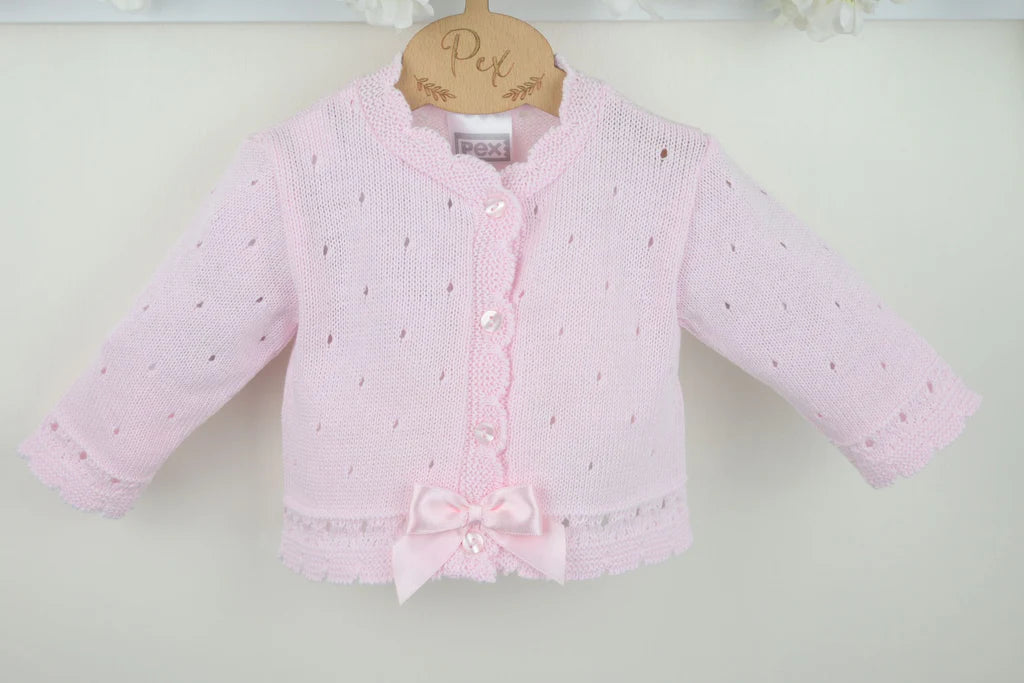 Pink baby cardigan with a bow on a white background