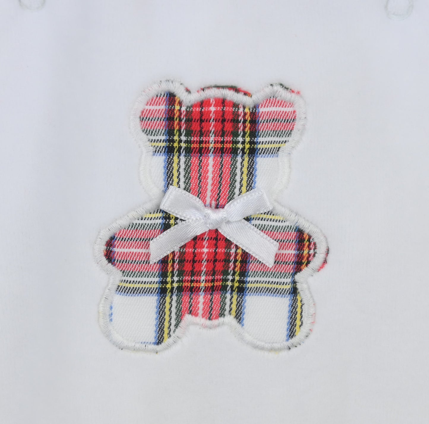 Plaid teddy bear patch with a white bow on a light gray background