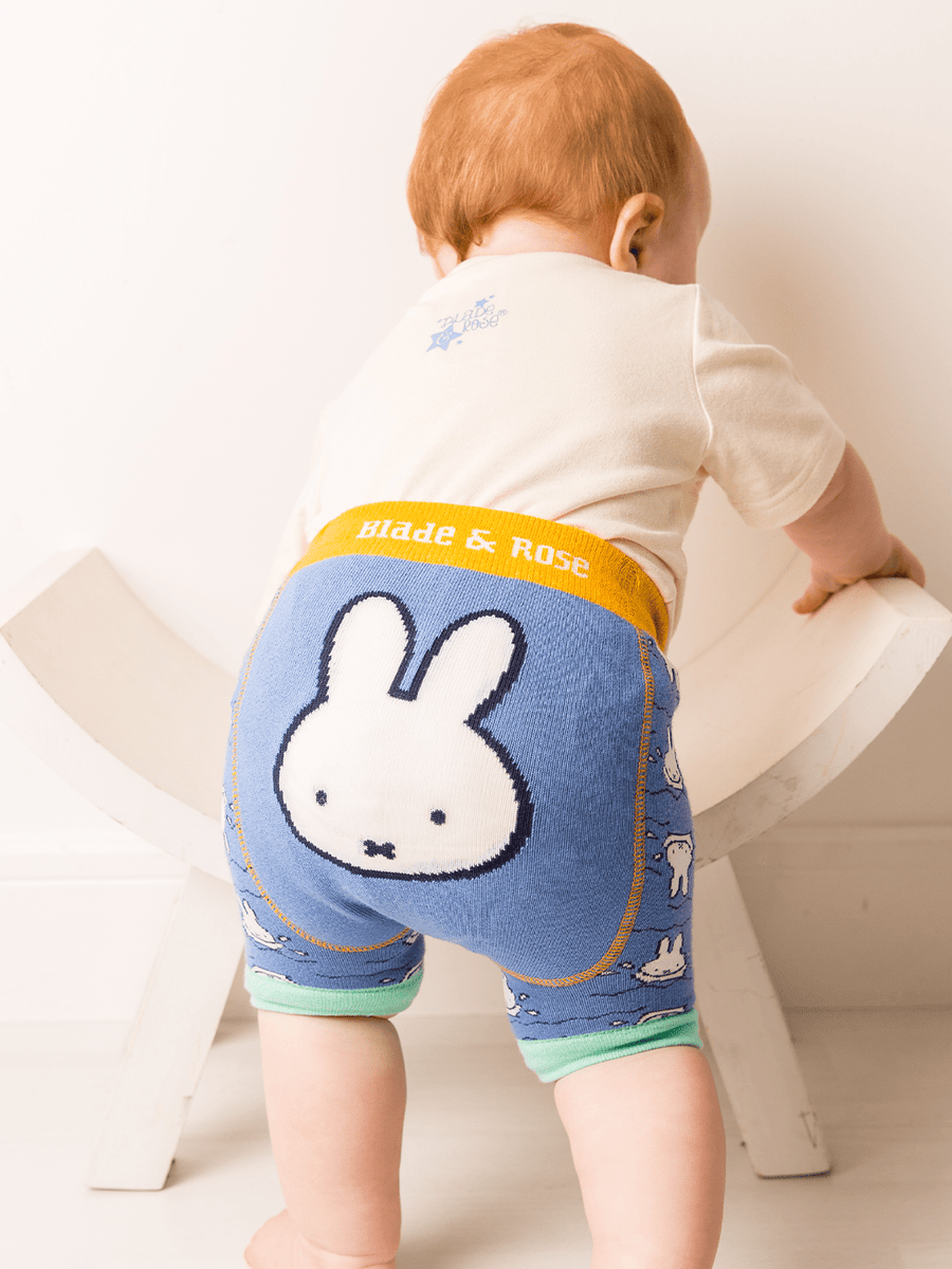 Child wearing blue shorts with a miffy cartoon character design on a white background