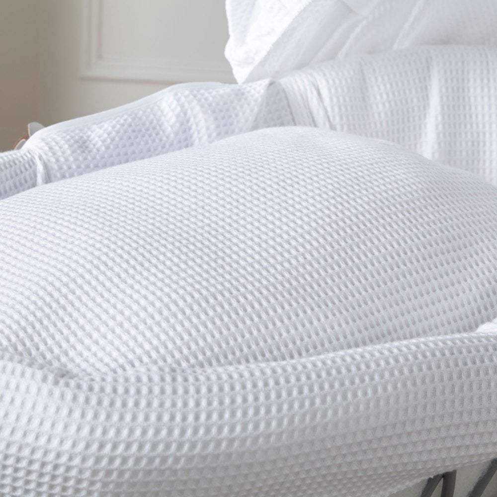 Close up of white waffle moses basket bedding