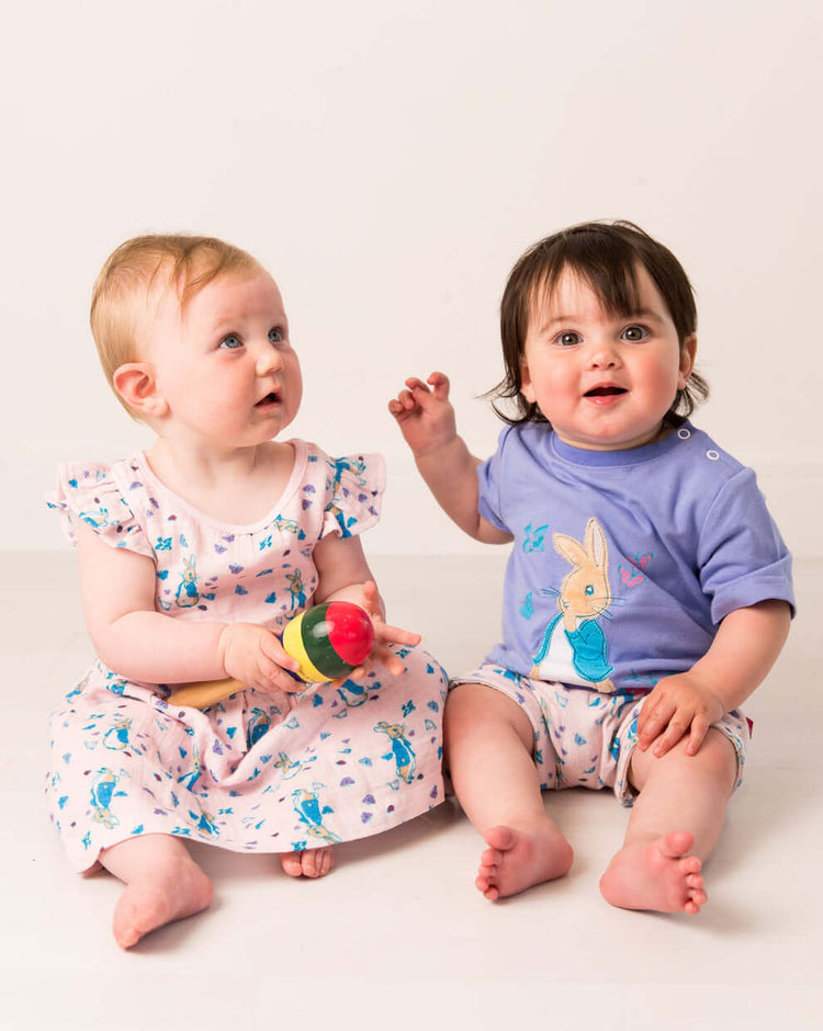 Two babies wearing Peter Rabbit Love Summer clothing.