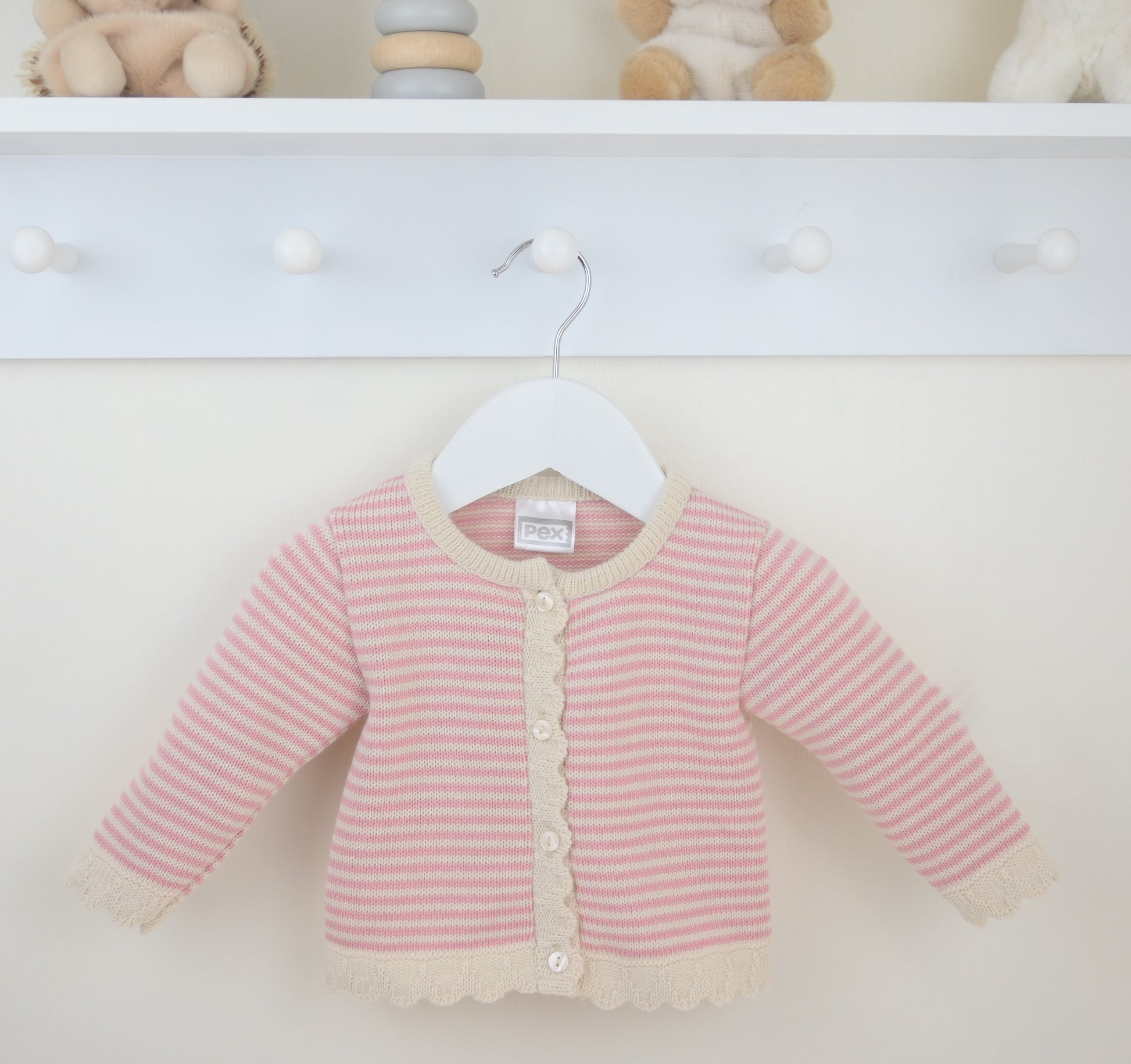 Pink striped baby cardigan on a hanger against a white background