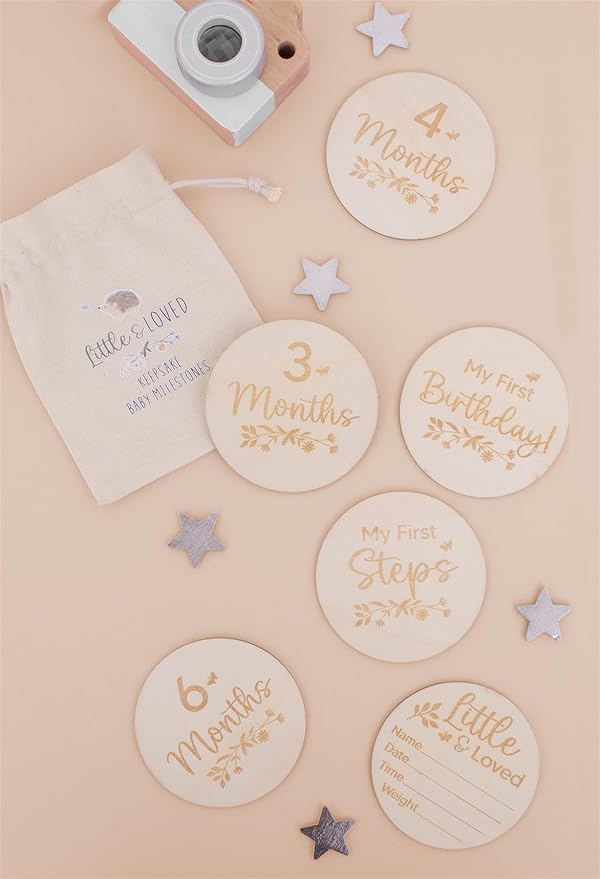 Wooden baby milestone discs on a beige background