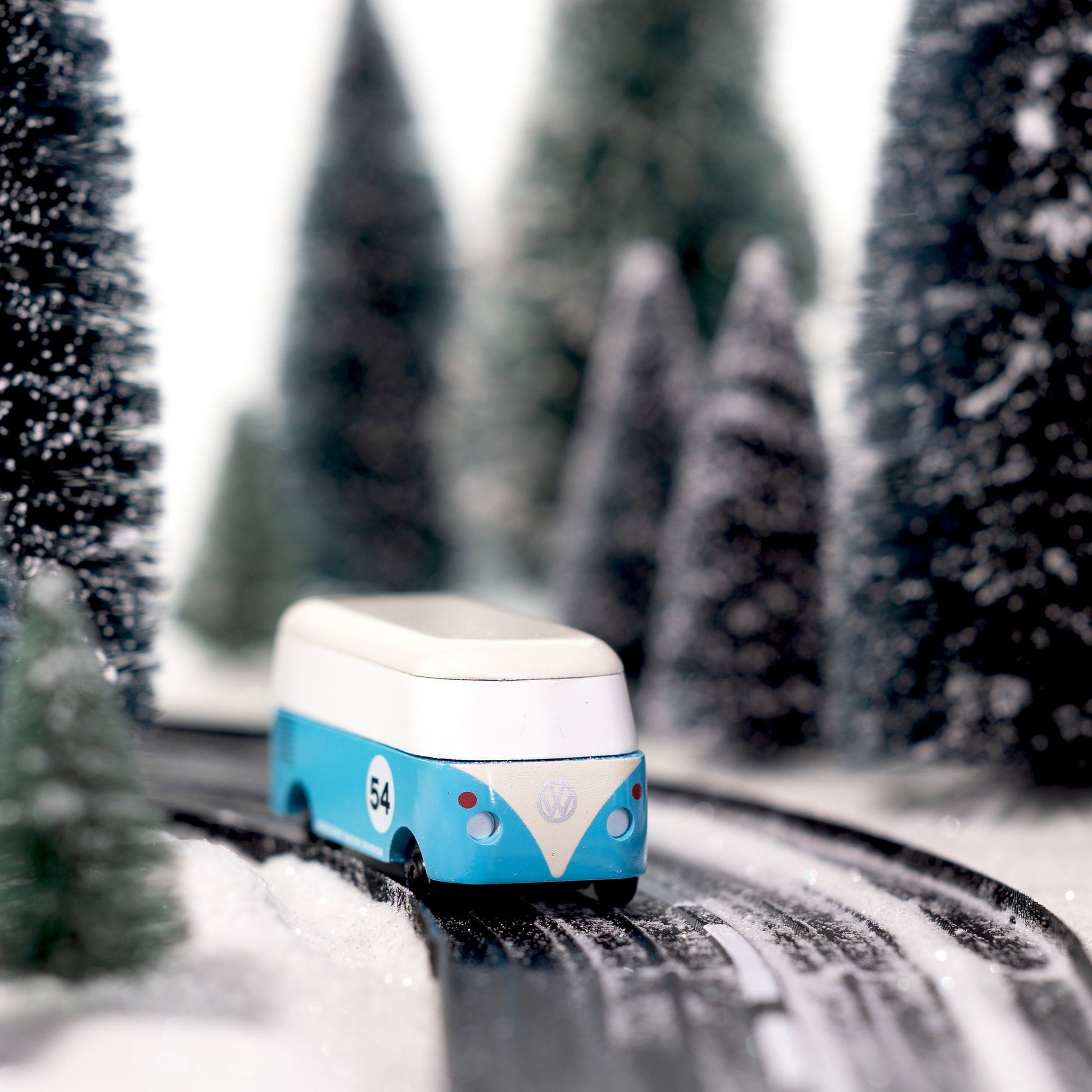 Toy van on a track with snow-covered trees in the background