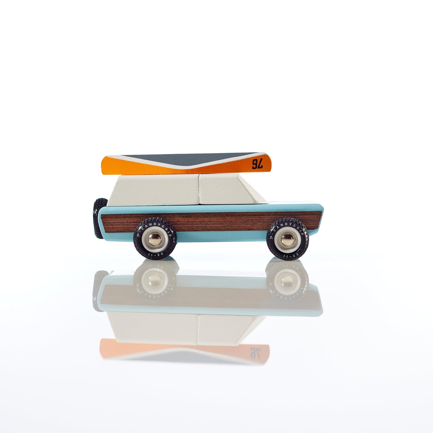 Toy truck with wooden design side and colorful top on a reflective surface