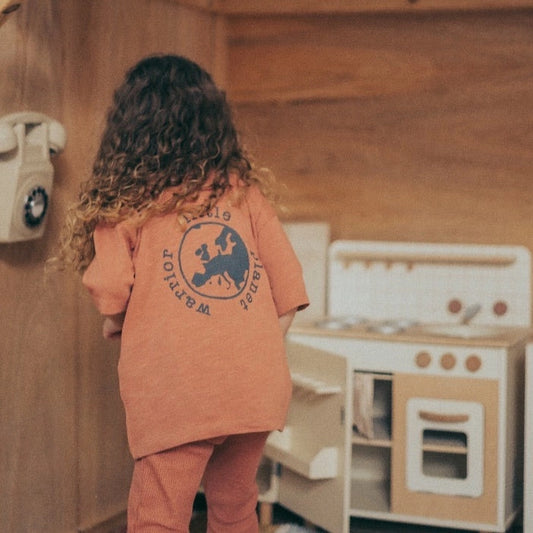 Child wearing Futuro Bambino Little Planet Warrior rust T-shirt