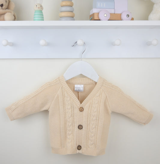 Beige baby cardigan on a hanger against a white background
