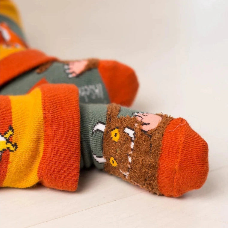 Pair of colorful socks with a Gruffalo design on a light background