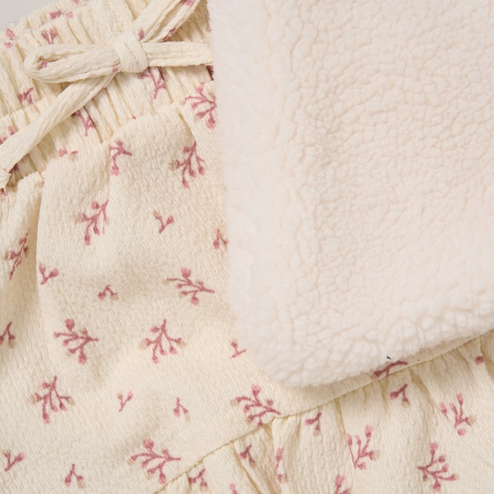Close-up of a textured fabric with floral pattern and tied bow