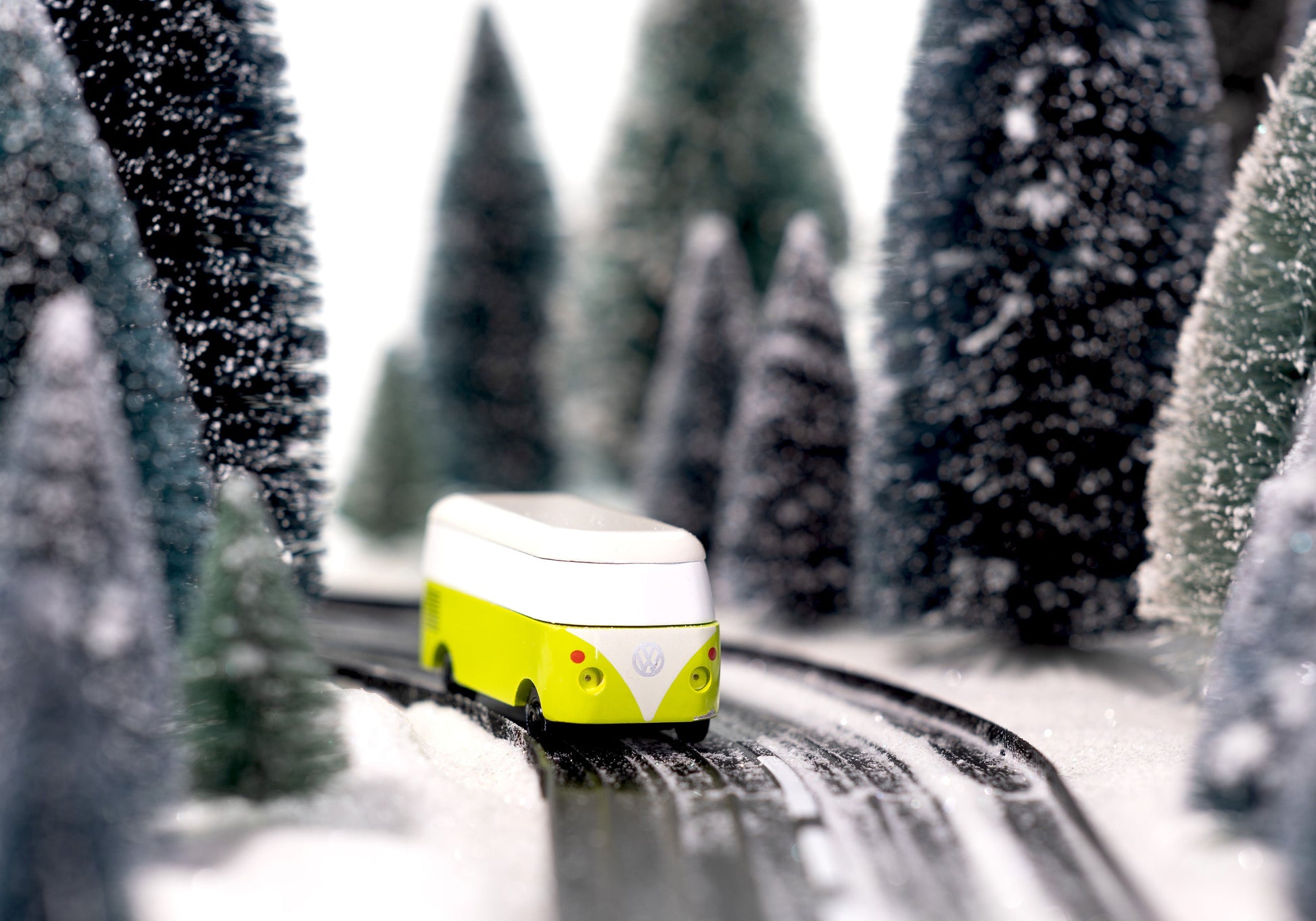 Toy van on a track surrounded by snow-covered trees
