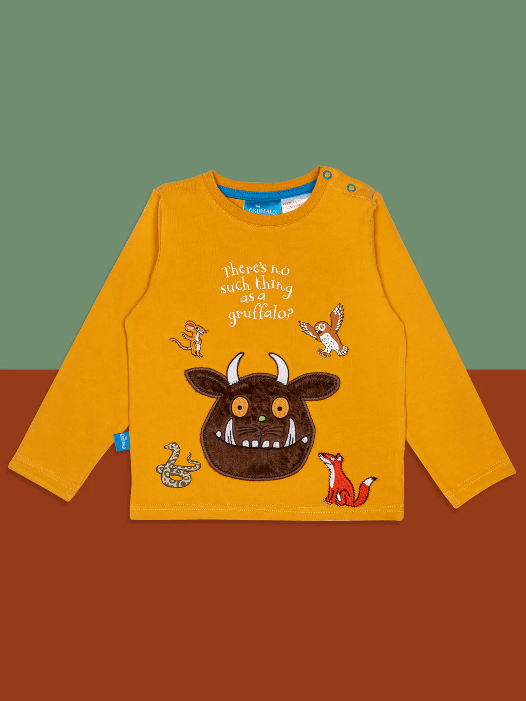 Yellow long-sleeve shirt with gruffalo character and text on a brown surface