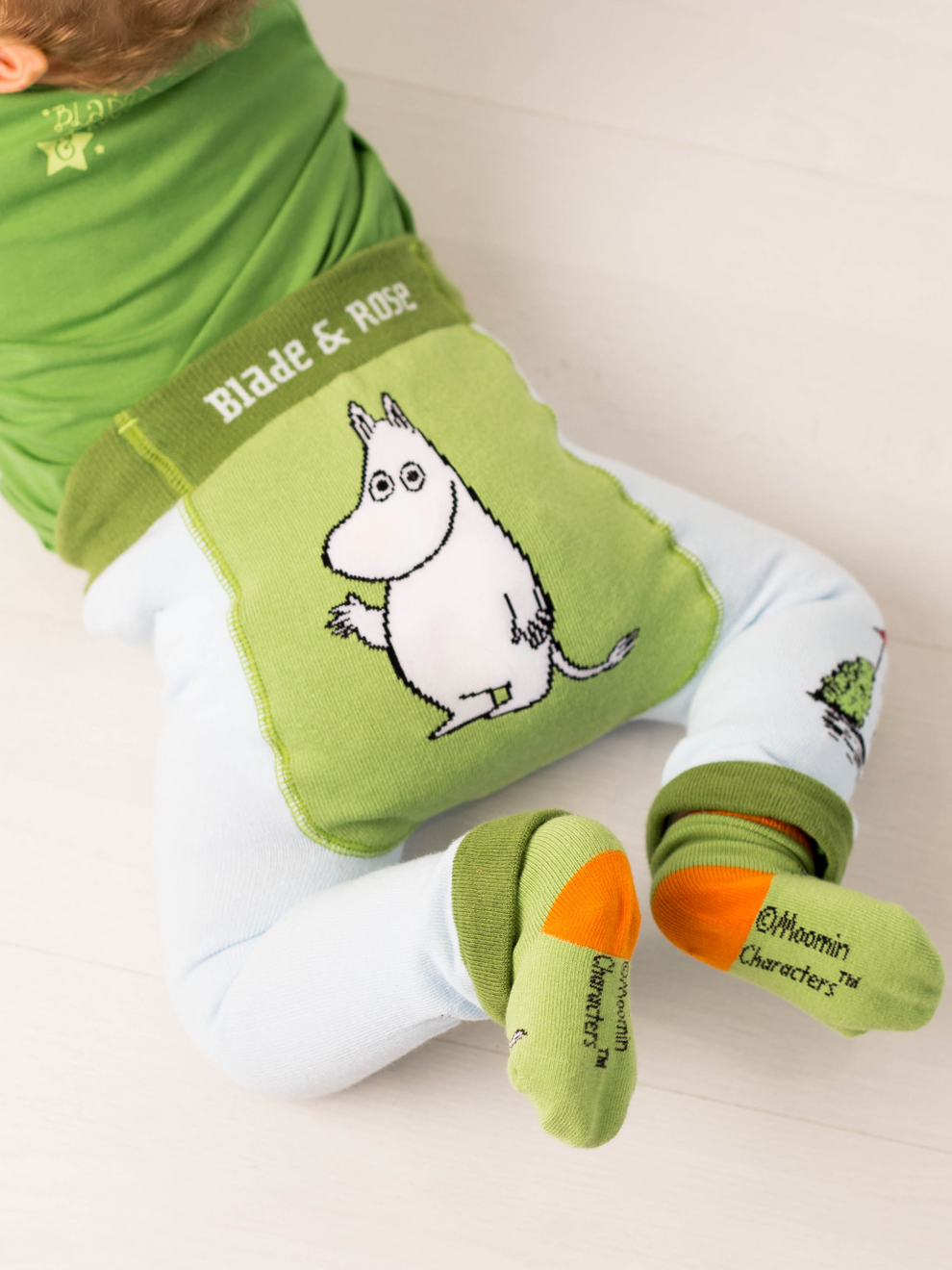 Child wearing green organic Moomin leggings with matching socks