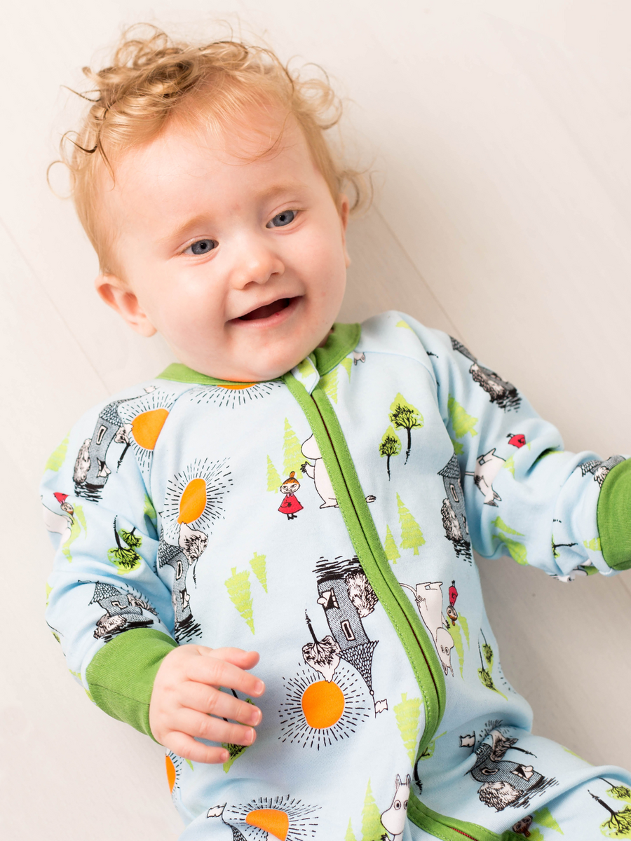 Baby wearing a colorful outfit with cartoon designs on a light background