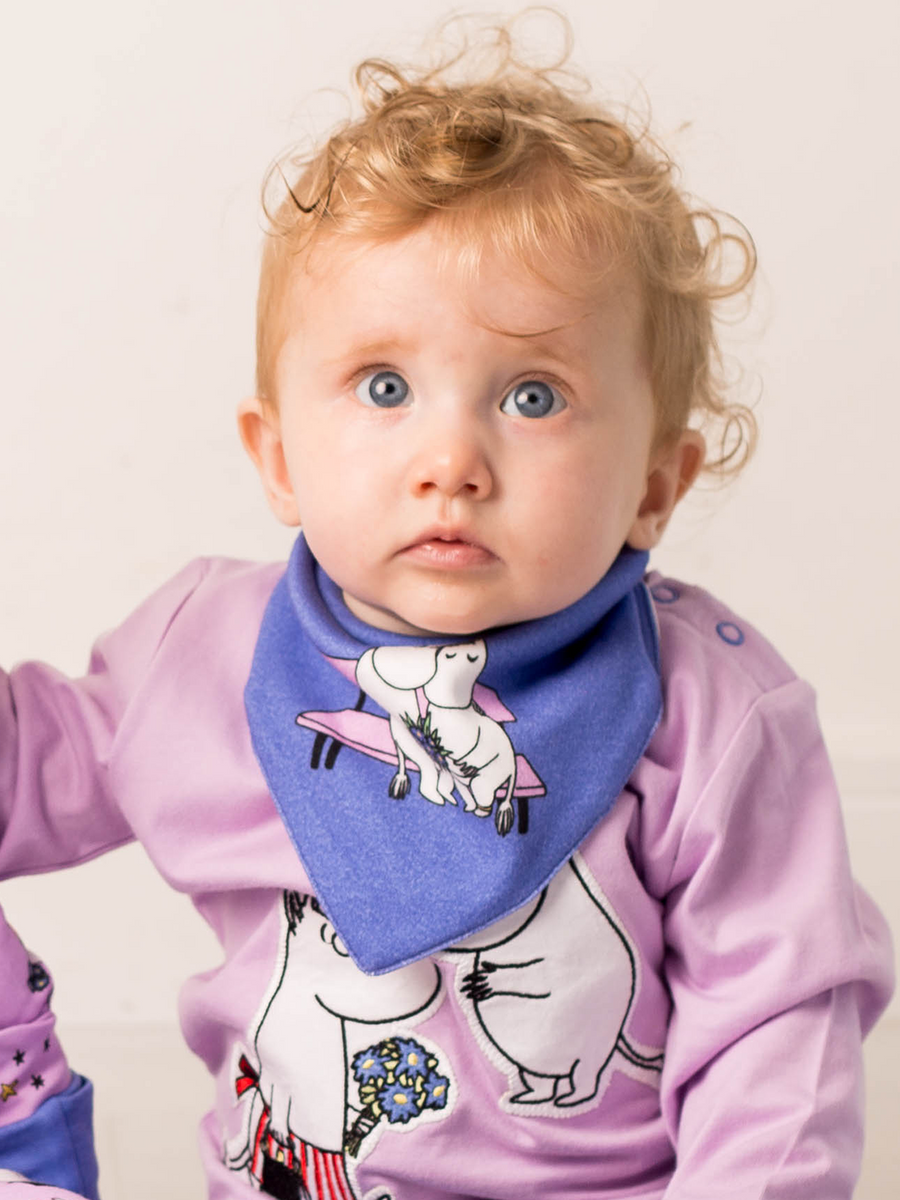 Child wearing purple Moomin top and blue Moomin character bib.