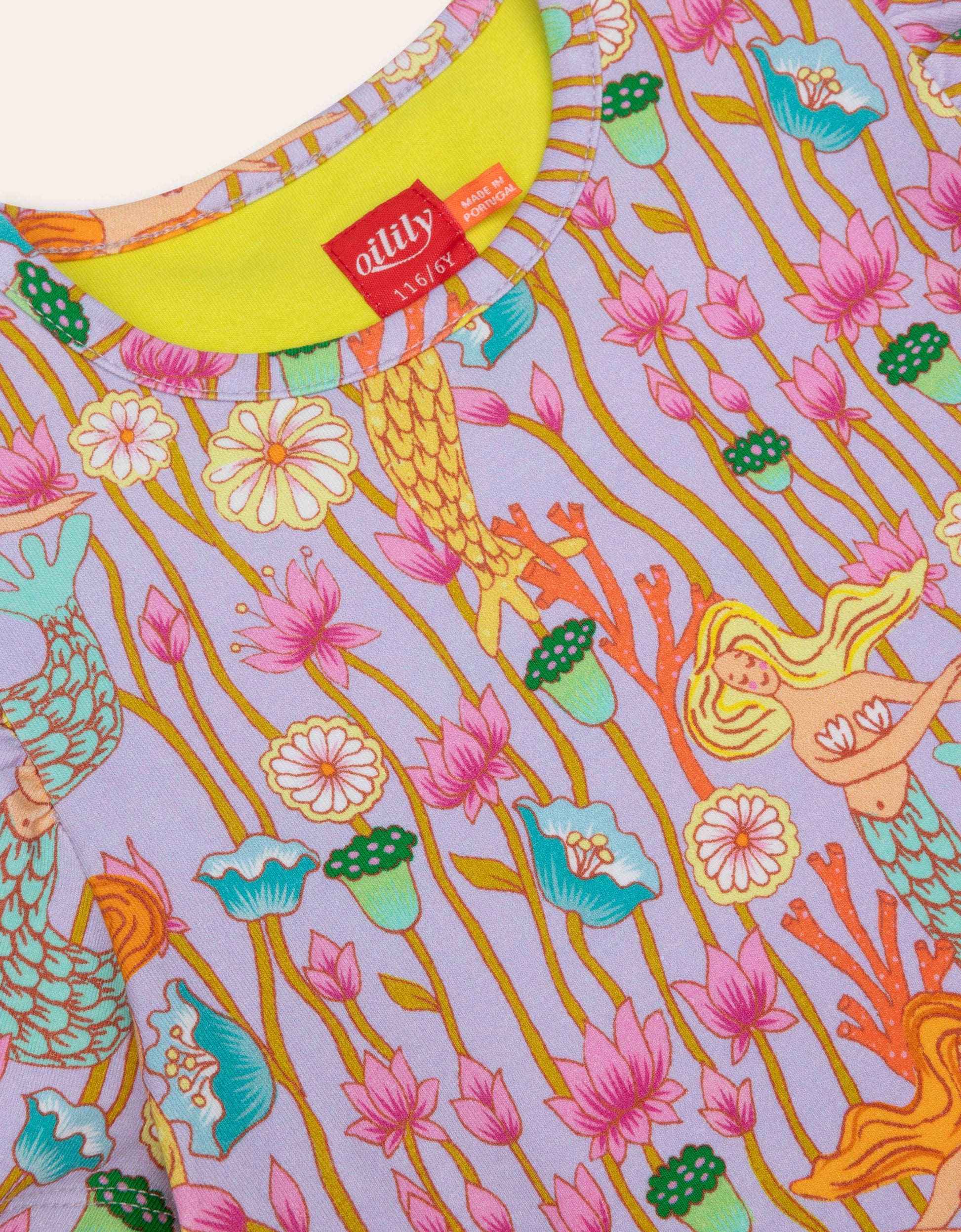 Colorful fabric with mermaid and floral pattern, featuring a visible Oilily brand label.