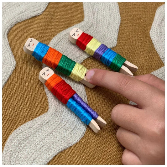 Colorful wooden spools with thread on a textured fabric background