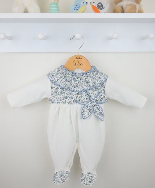 White baby romper with floral top on a hanger against a white background