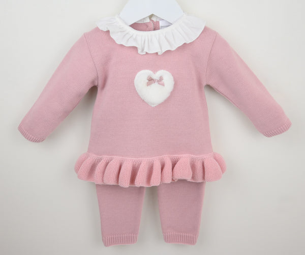 Pink baby outfit with ruffled collar and heart design on a white background