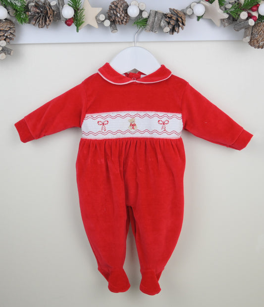 Red baby onesie with Christmas trim on a white background