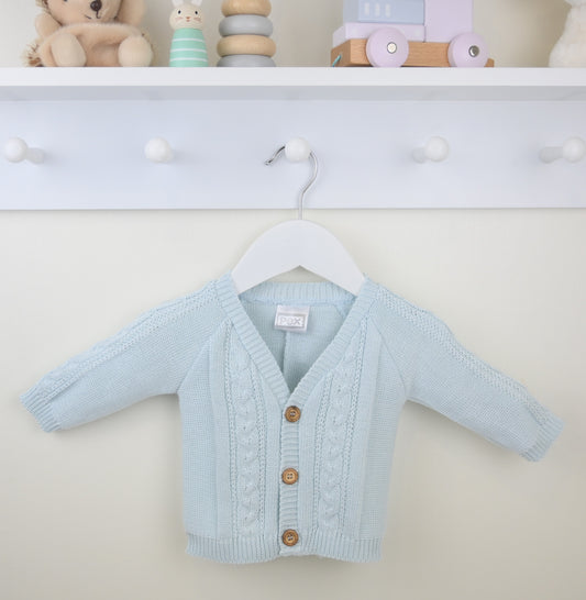 Light blue baby cardigan with wooden buttons on a hanger against a white wall.