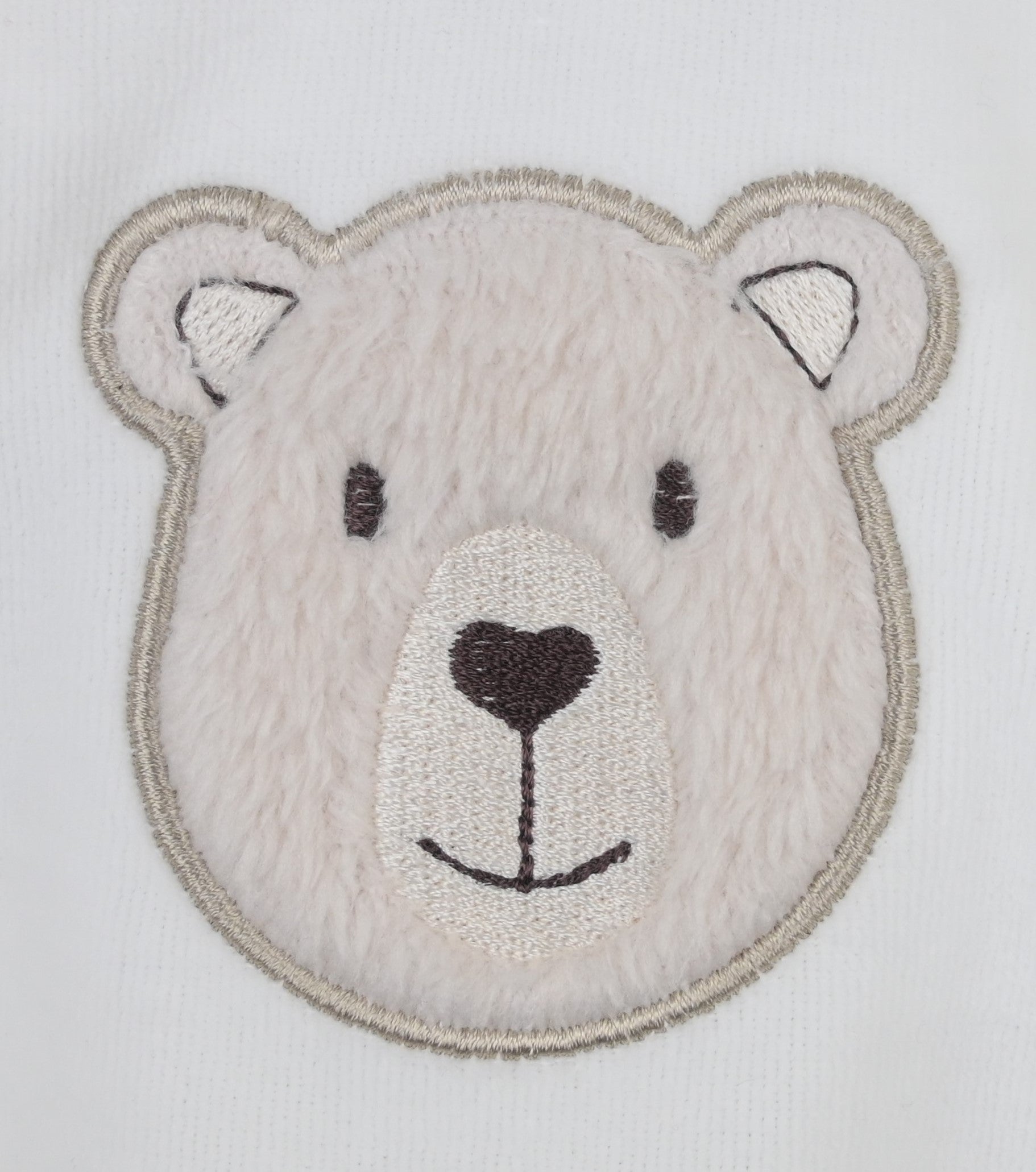 Embroidered patch of a bear's face on a white background