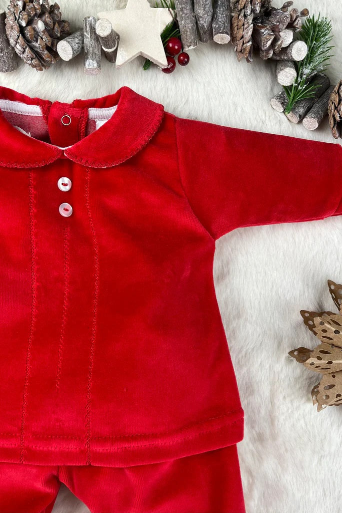 Red velvet outfit with a collar on a white background with Christmas decorations.
