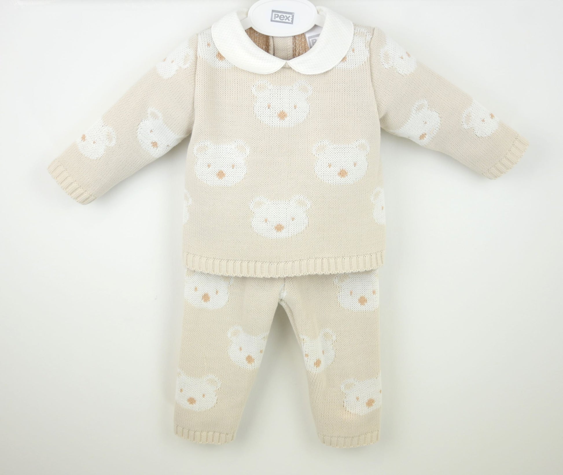 Beige baby sweater and pants set with white bear patterns on a white background