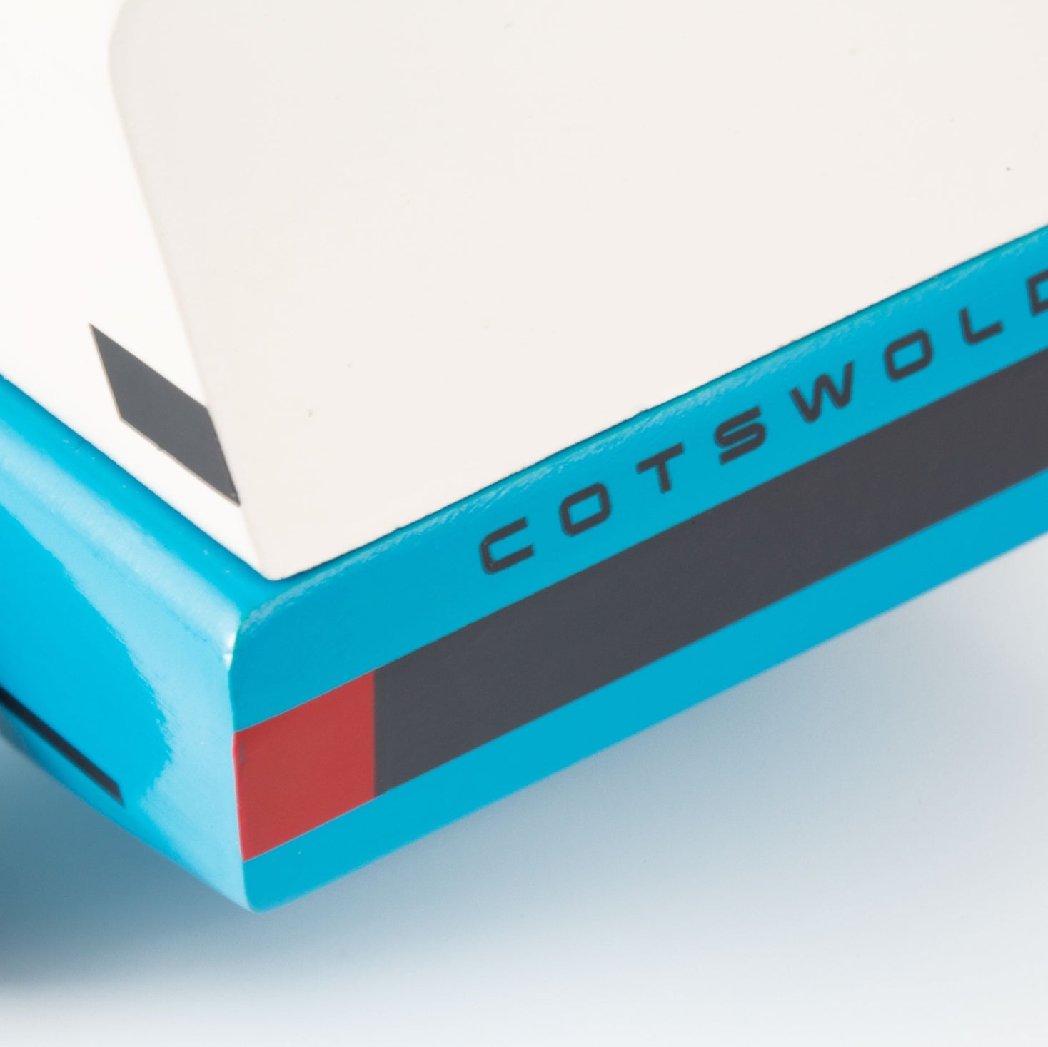 Close-up of a blue product with 'Cotswold' branding on a light gray background
