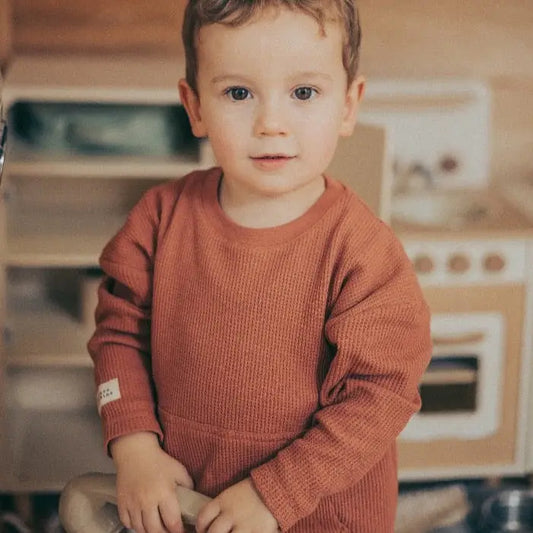 Child wearing rust organic cotton waffle top