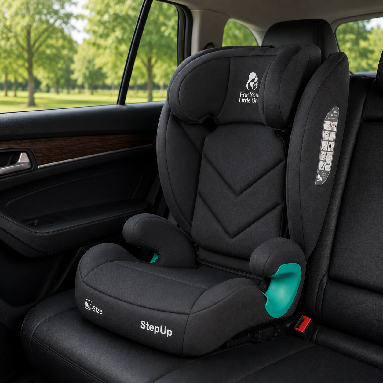 A black StepUp car seat installed on a car seat, shown from the side. The car interior is visible, with a green park background seen through the window.