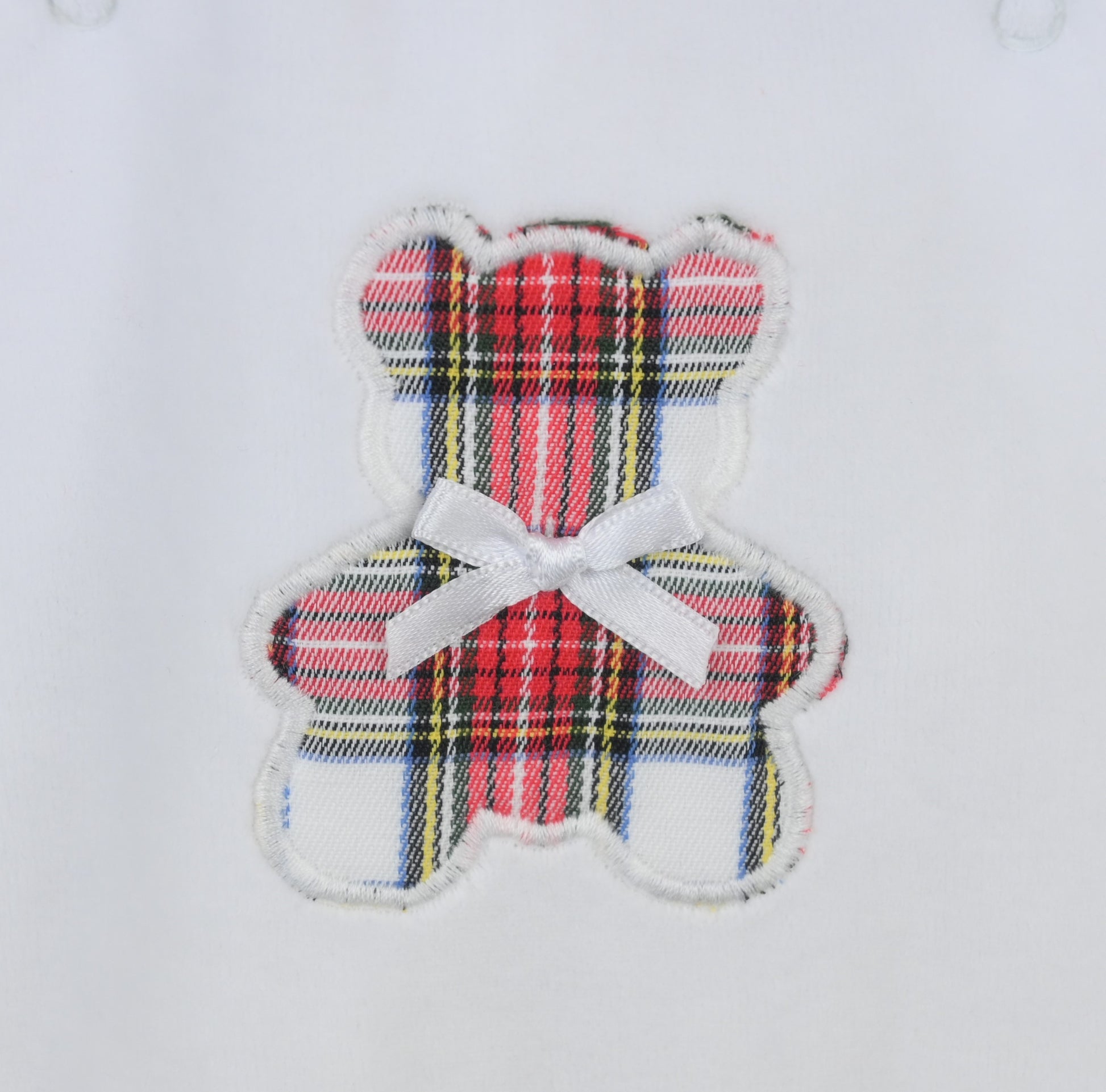 Plaid teddy bear patch with a white bow on a light gray background