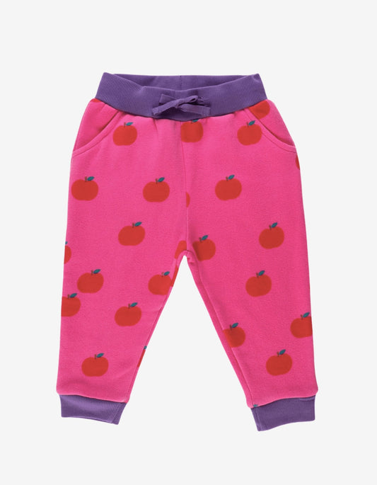 Pink children's pants with apple pattern and purple accents on a white background