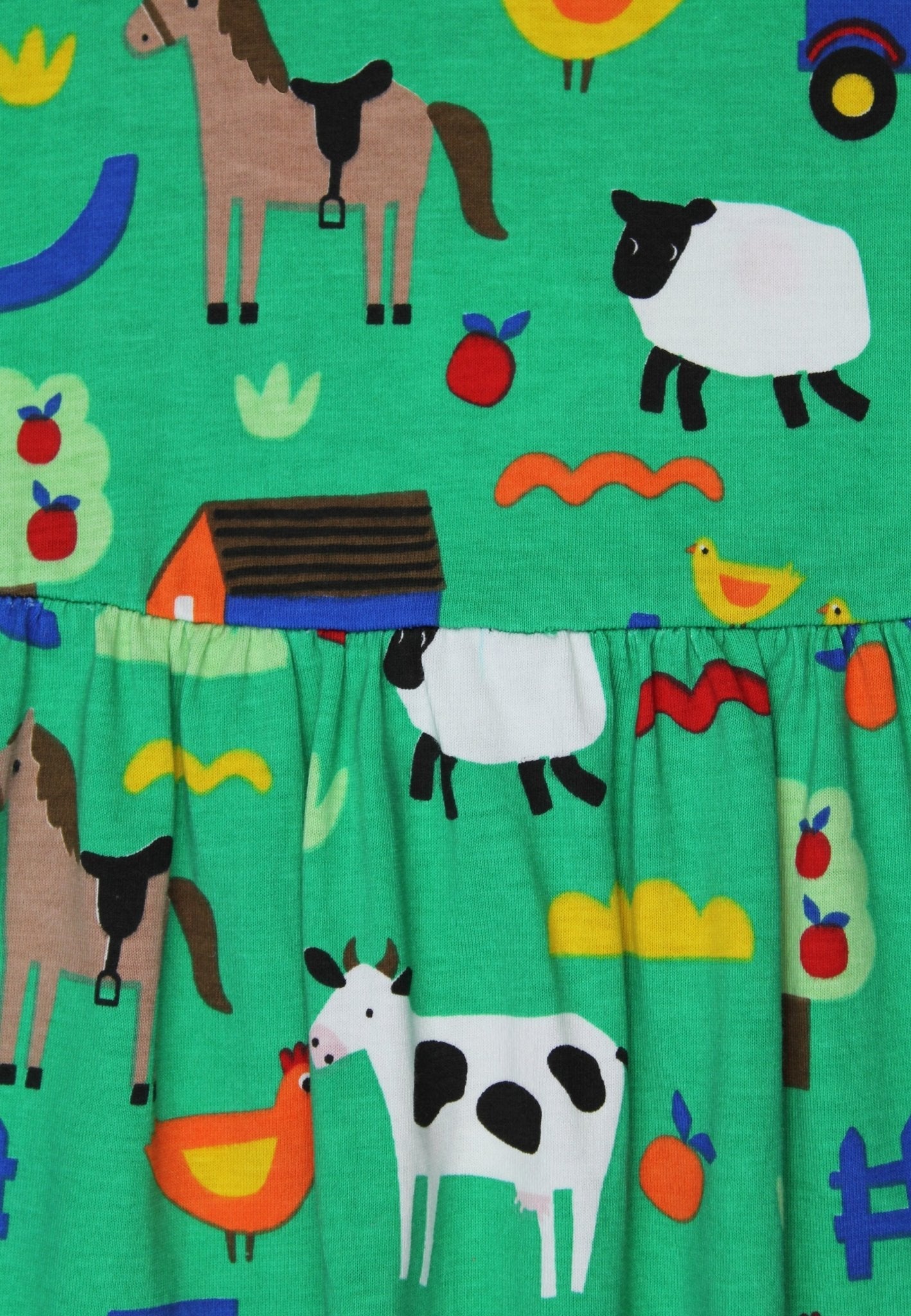 Children's dress with farm animal pattern on a green background