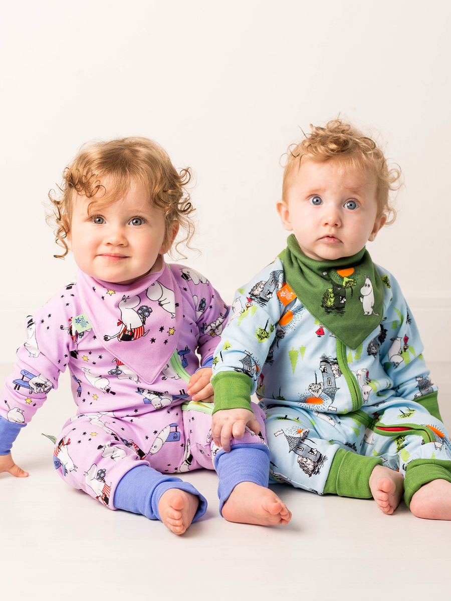 Two children wearing colorful pajamas with moomin designs on a white background