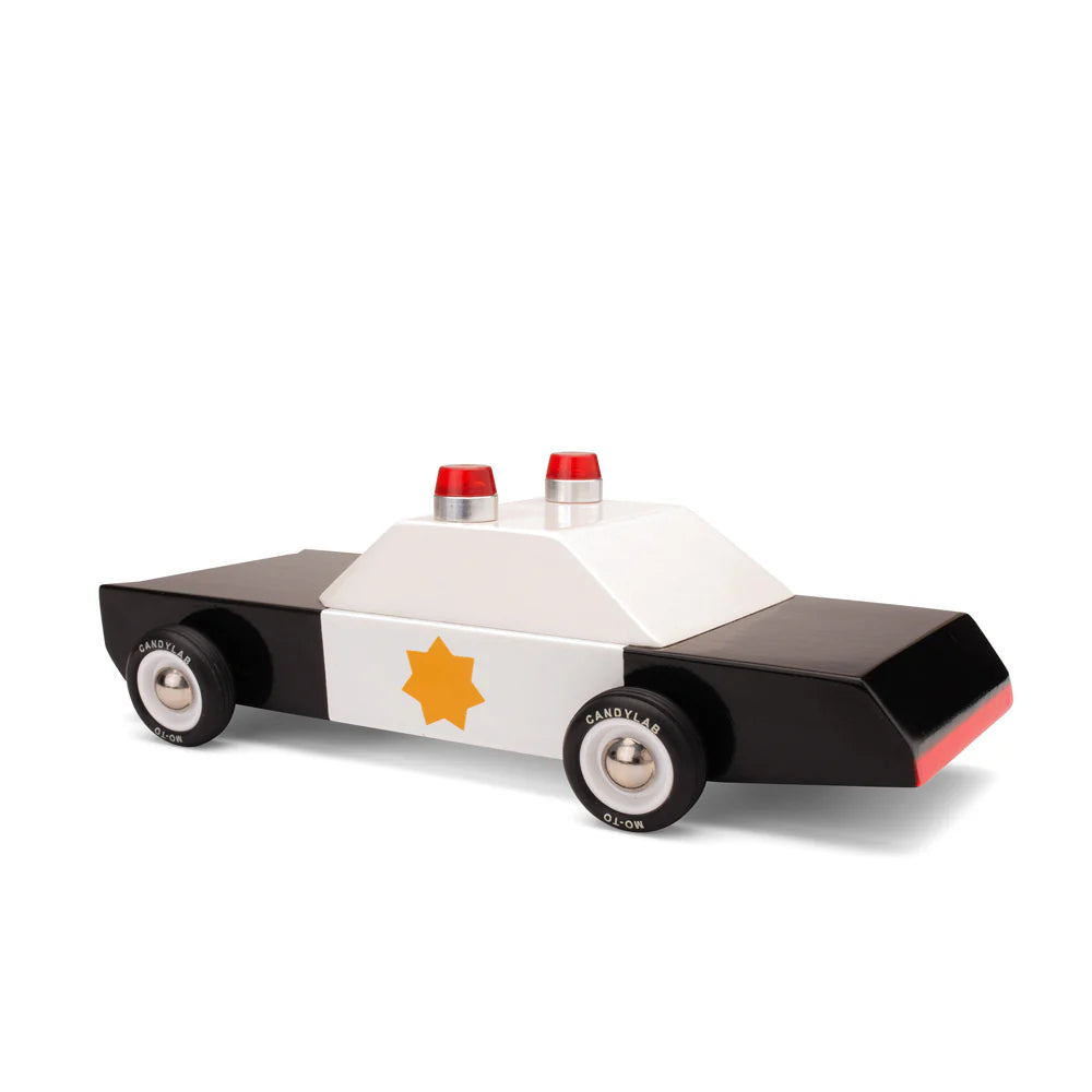 Toy police car with a white body, black sides, and red accents on a white background